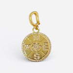 Gold compass charm with starburst center, pavé crystal edge, and lobster clasp for versatile wear