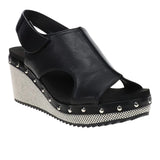 Black wedge sandals with slingback strap and studded sole detail.