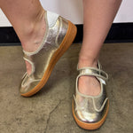 Corky's metallic gold flats with white stripes and adjustable Velcro strap.