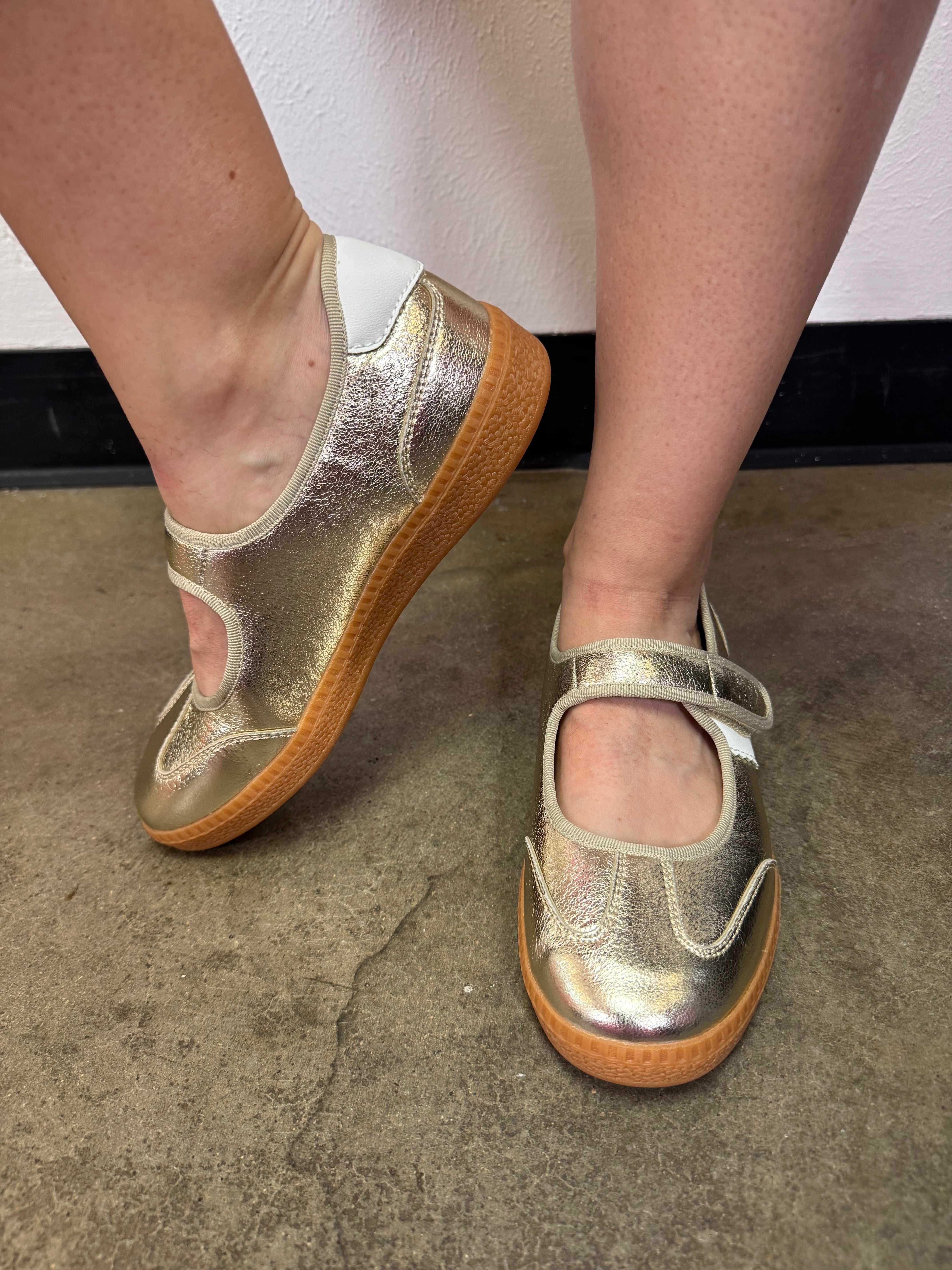 Corky's metallic gold flats with white stripes and adjustable Velcro strap.