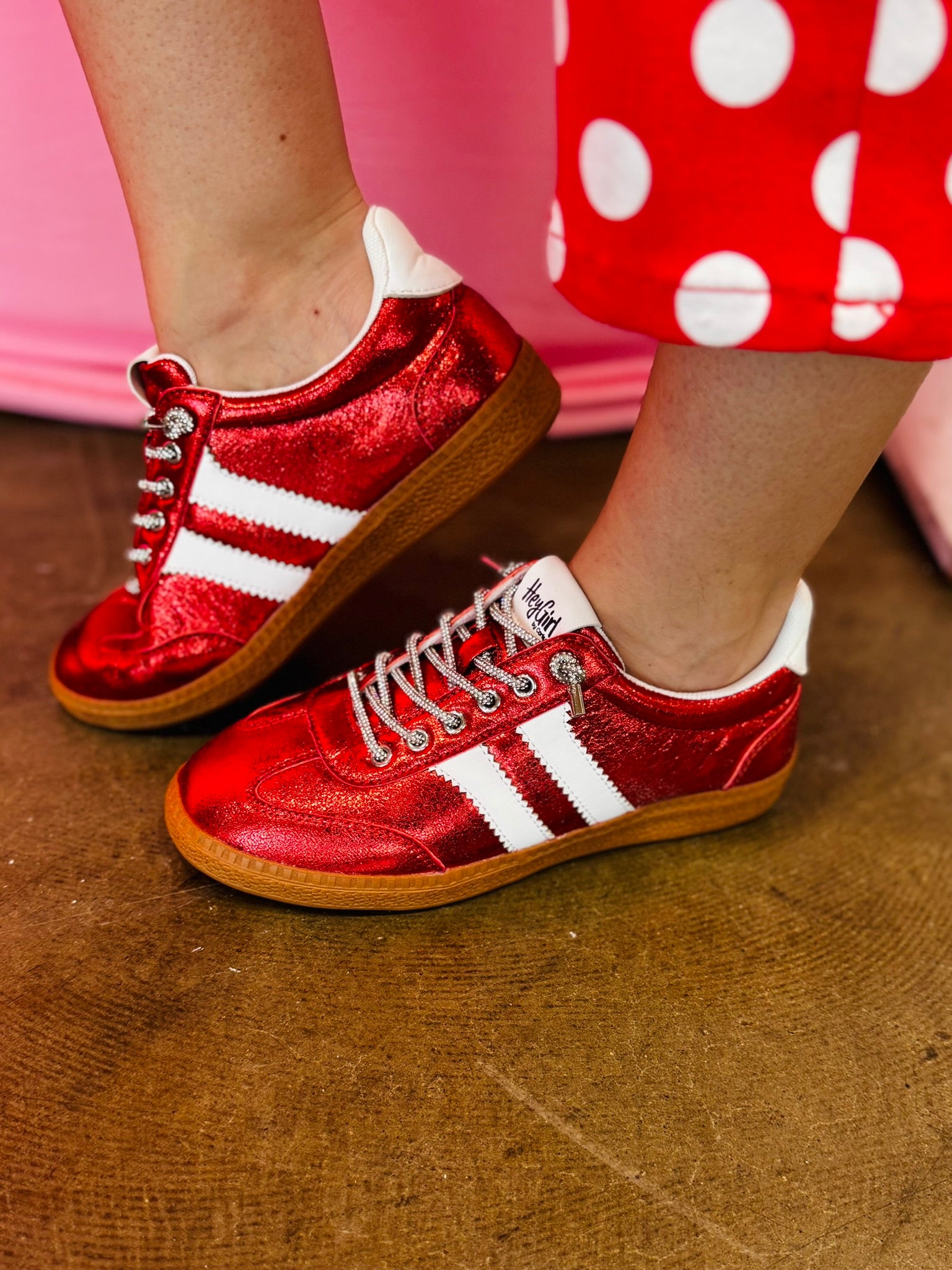 Metallic red Corky's sneakers with white side stripes and lace-up closure.