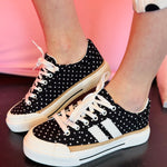 Black and white polka dot sneakers with bold side stripes and classic lace-up design