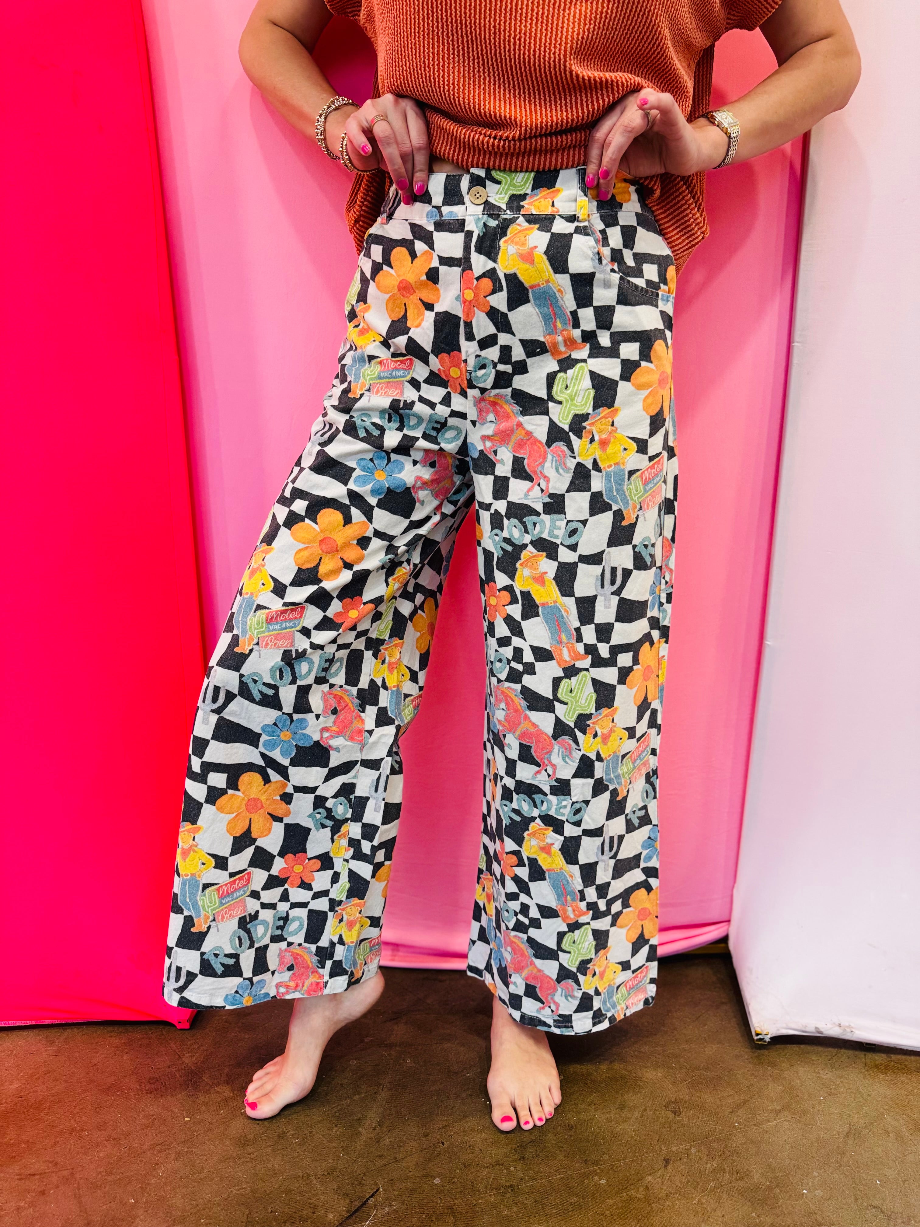 Black and white checkered wide-leg pants with colorful Western rodeo graphics.