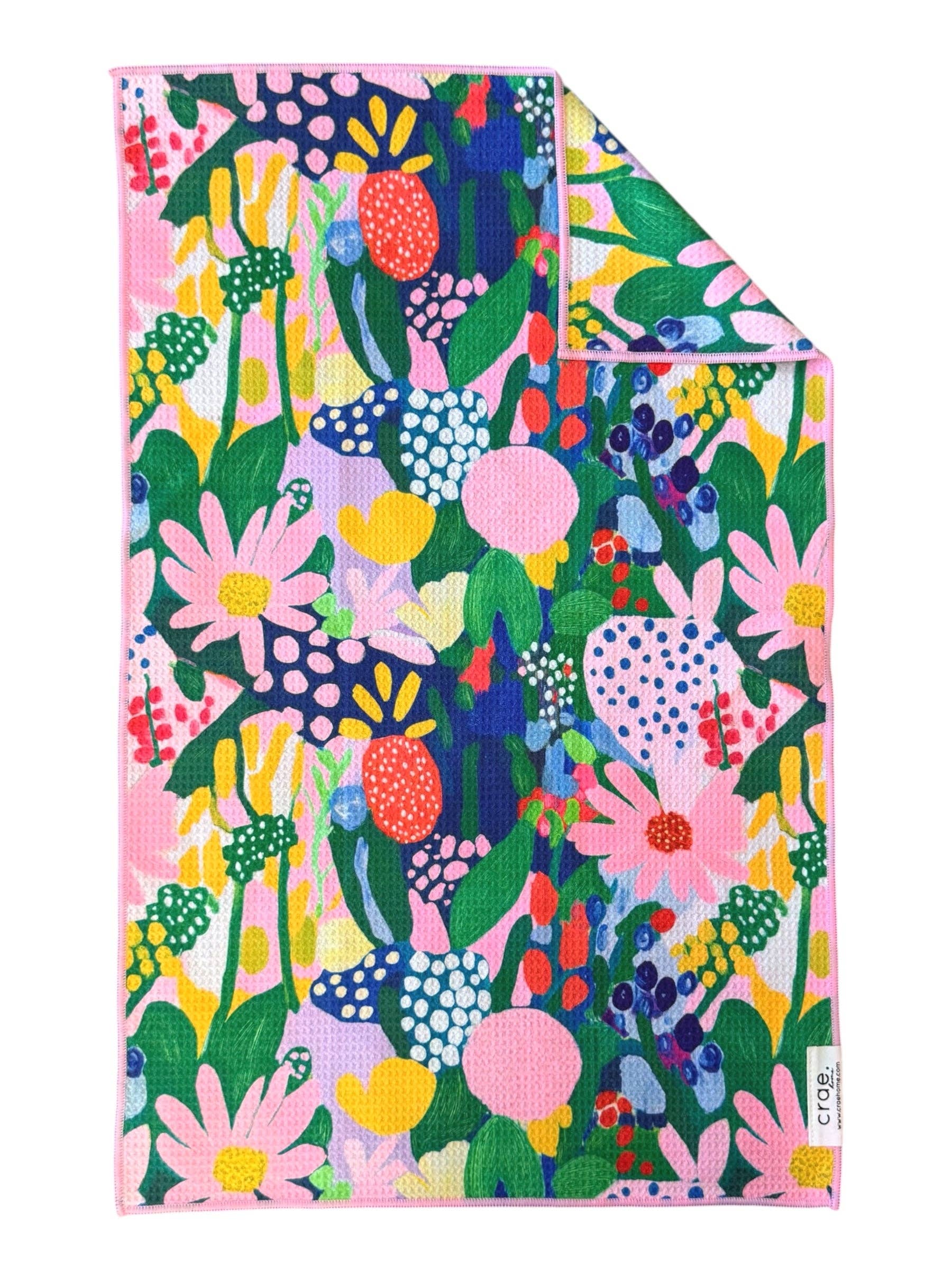 Crae Aster hand towel with colorful abstract flowers, leaves, dots, and whimsical shapes.