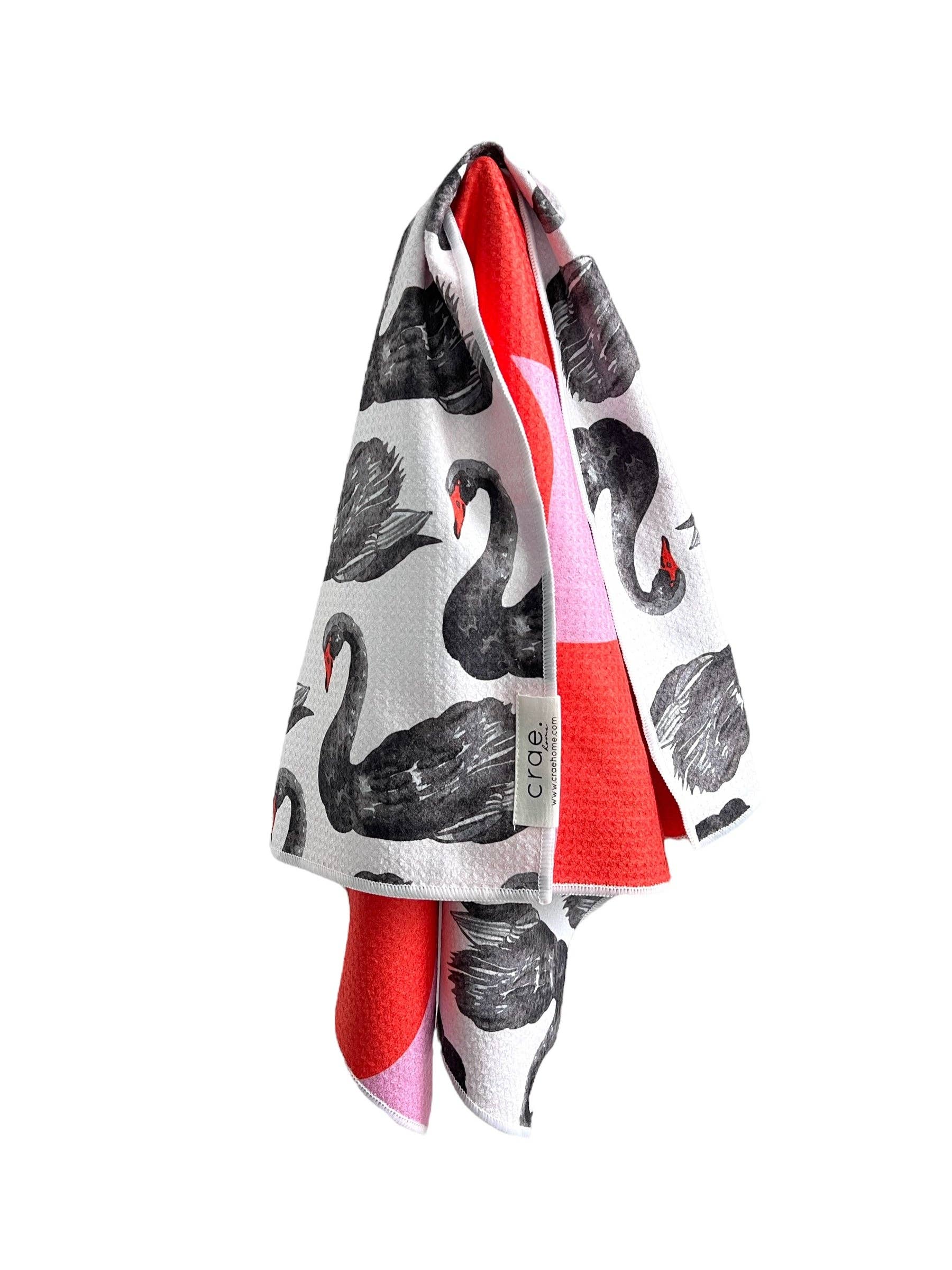 Reversible hand towel with black swans and red pink checkerboard print.
