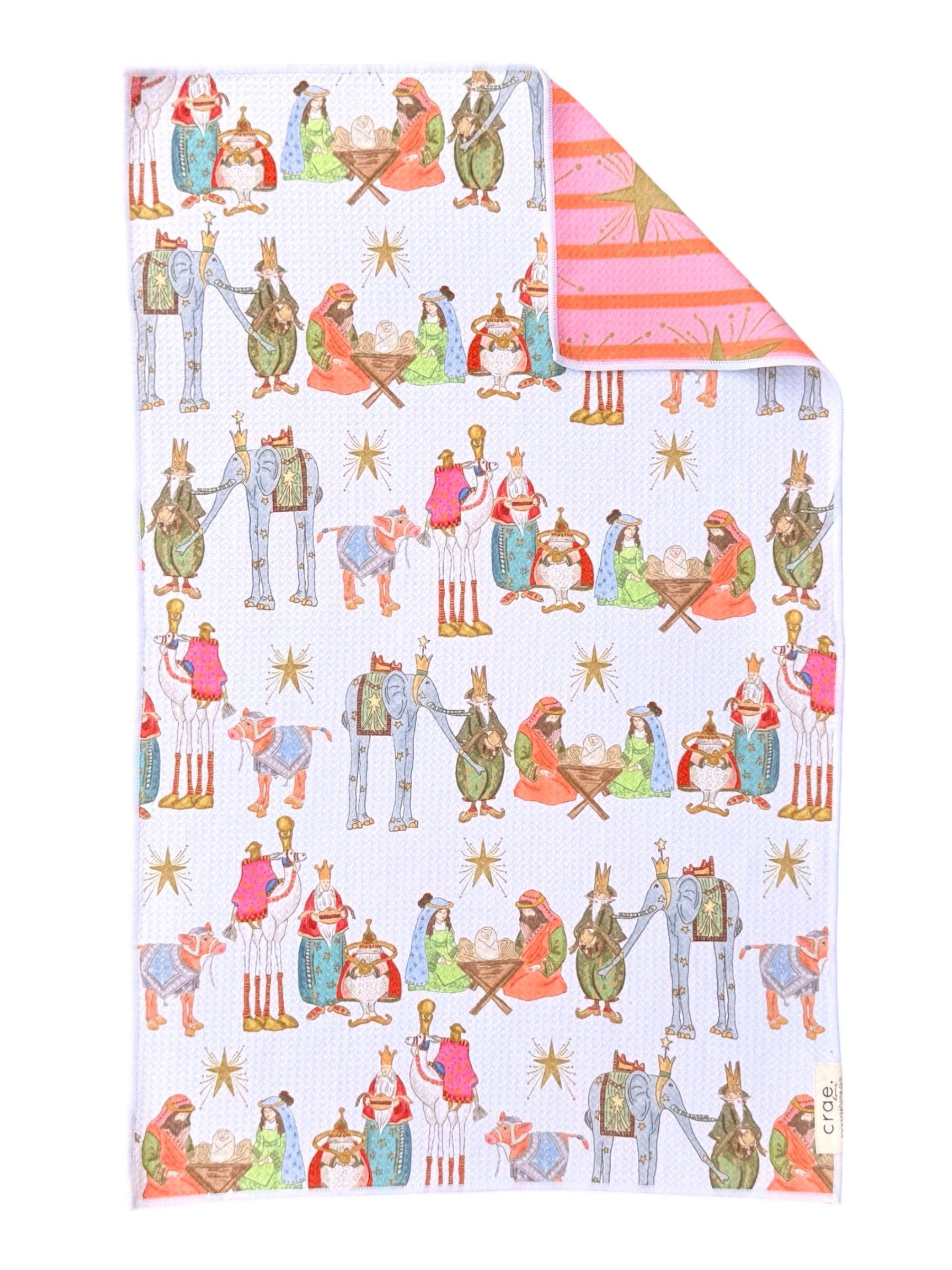 Reversible Christmas towel with colorful Nativity scene and pink striped reverse with gold starbursts.