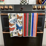 Two Crae hand towels with colorful butterfly and multicolor striped designs.