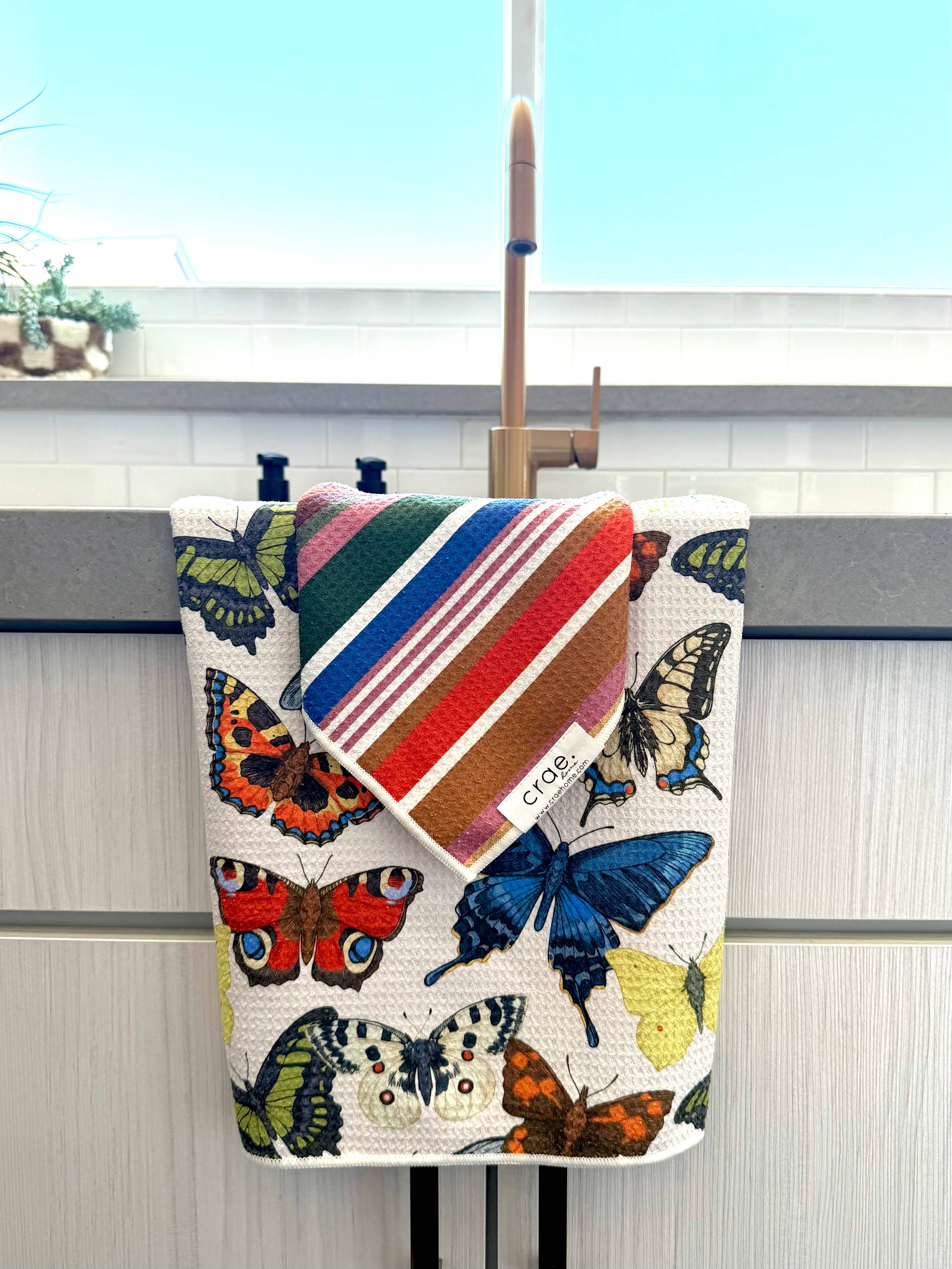 Butterfly hand towel and colorful striped washcloth set in vibrant jewel tones.