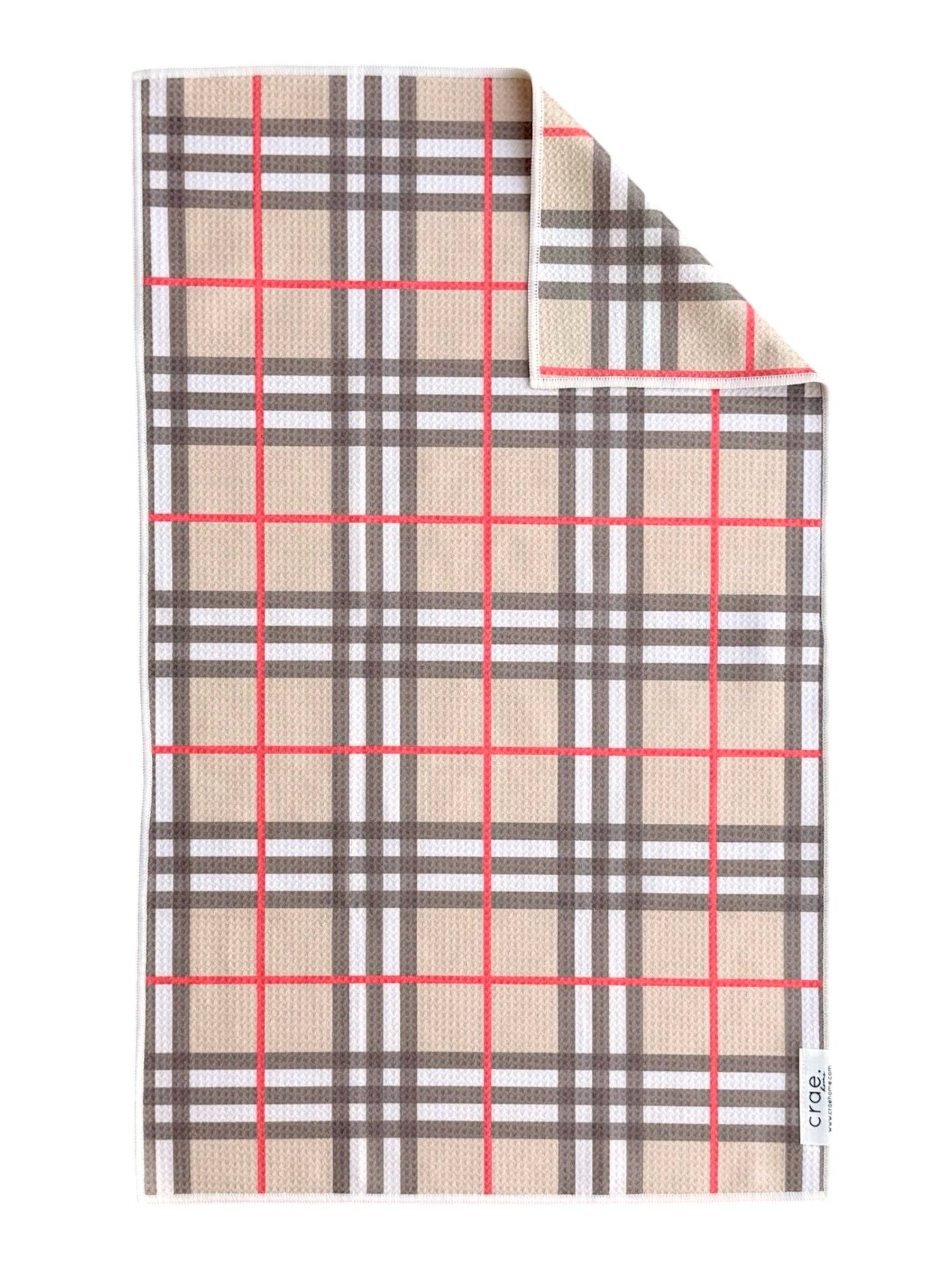 Tan plaid hand towel with bold black, white and red lines.