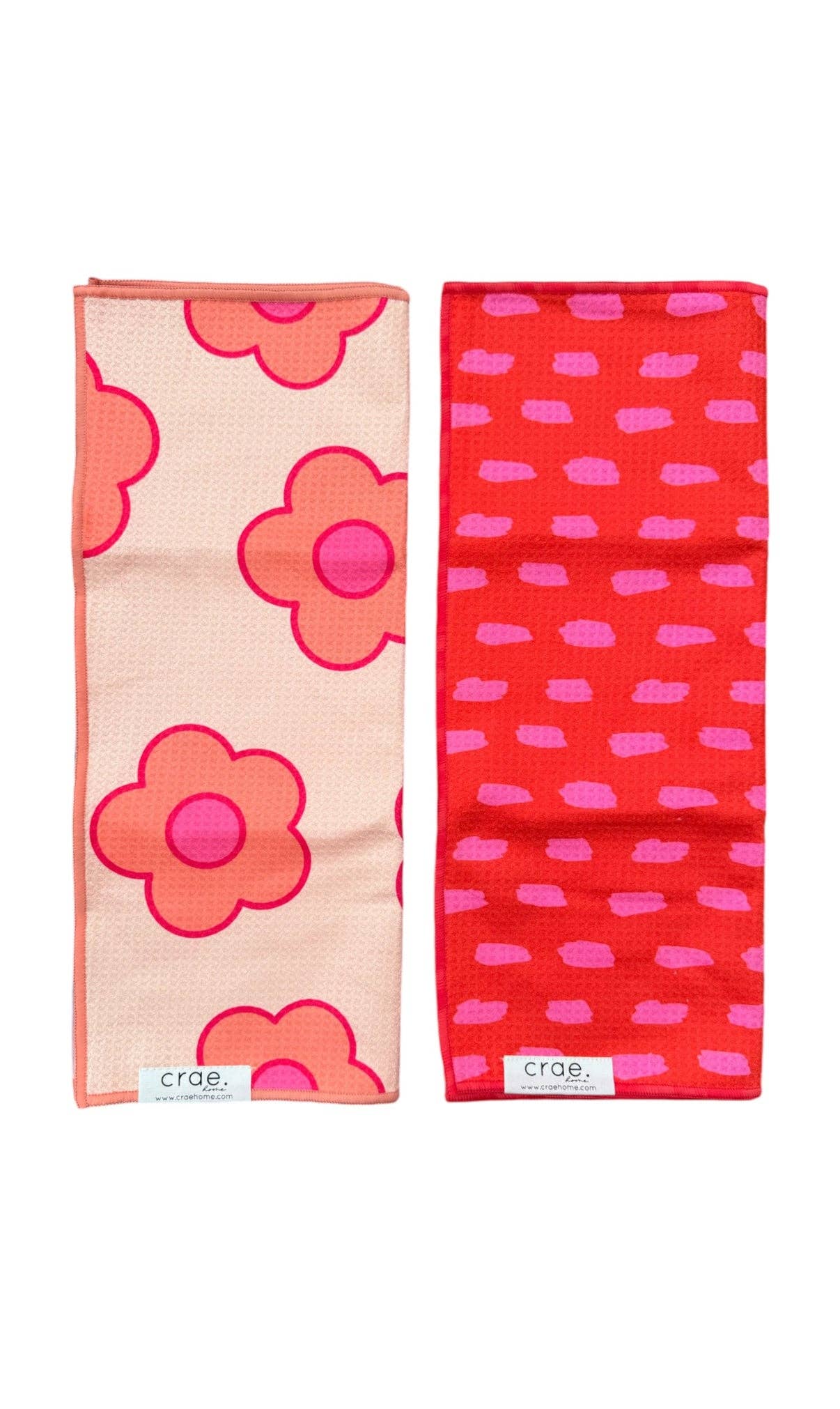 Two Crae hand towels with peach pink florals and red pink dash print.