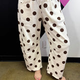 Cream barrel-leg pants with bold brown polka dots and elastic waistband.