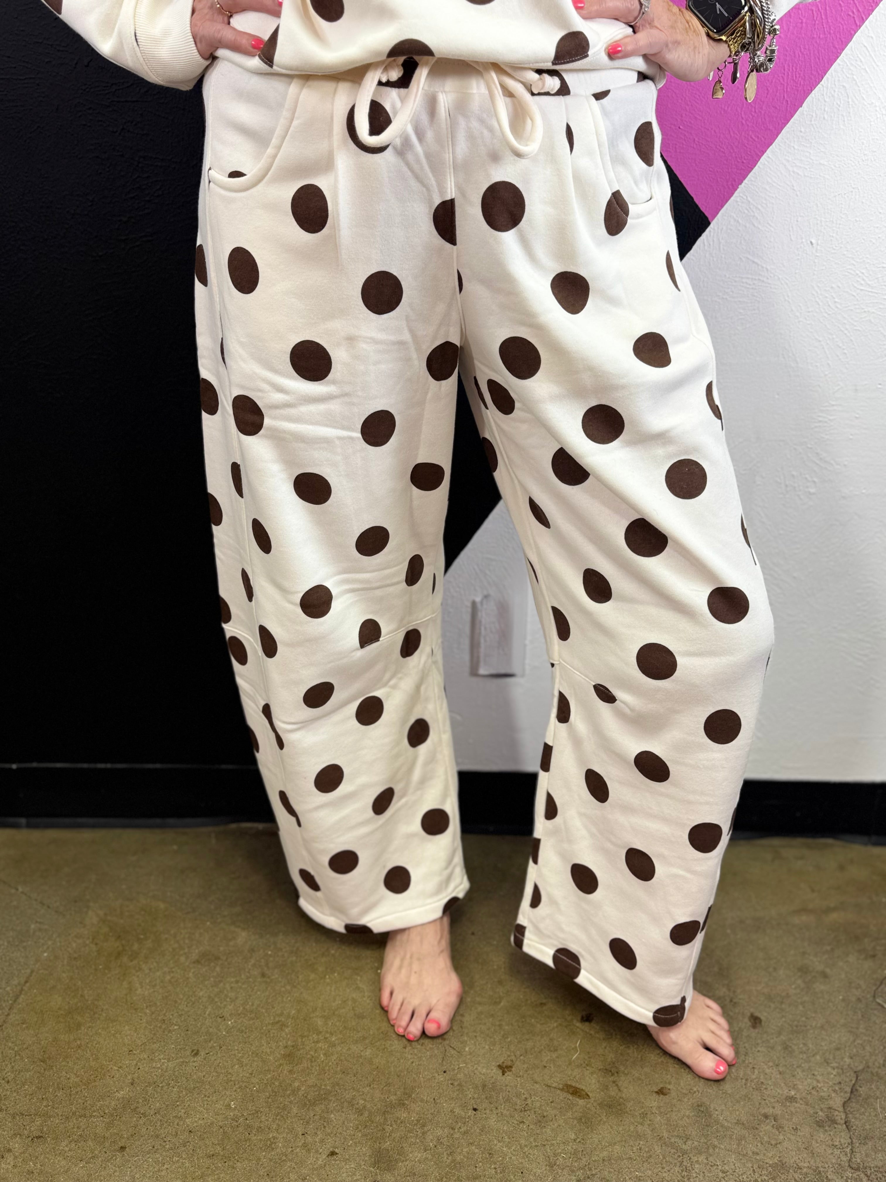 Cream barrel-leg pants with bold brown polka dots and elastic waistband.