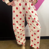 Cream barrel-leg pants with bold red polka dots and elastic waistband.
