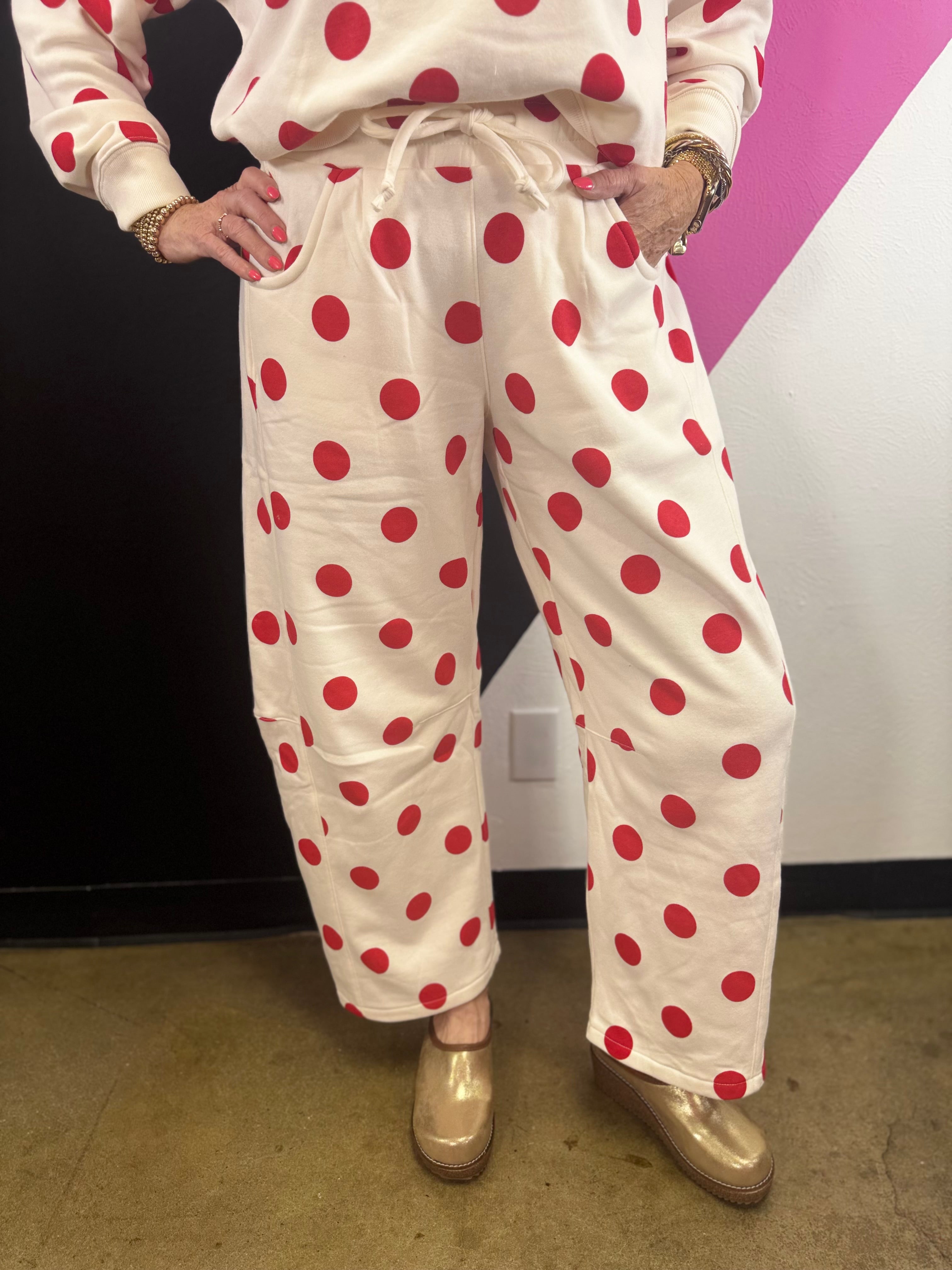 Cream barrel-leg pants with bold red polka dots and elastic waistband.