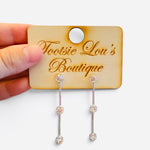 Silver bar drop earrings with three round-cut crystals and polished vertical bars.