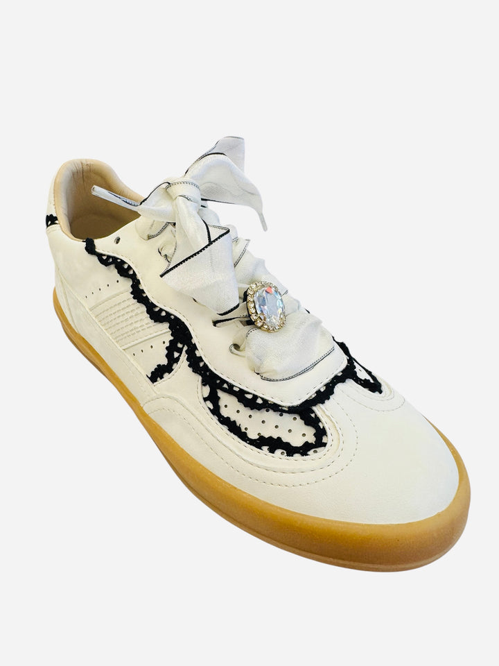 White low-top sneakers with vegan leather upper, delicate lace trim, lace-up closure, and round toe.