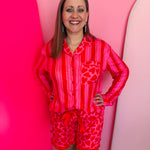 Red striped heart-pocket pajama top with matching heart-print ruffle shorts and bow detail.