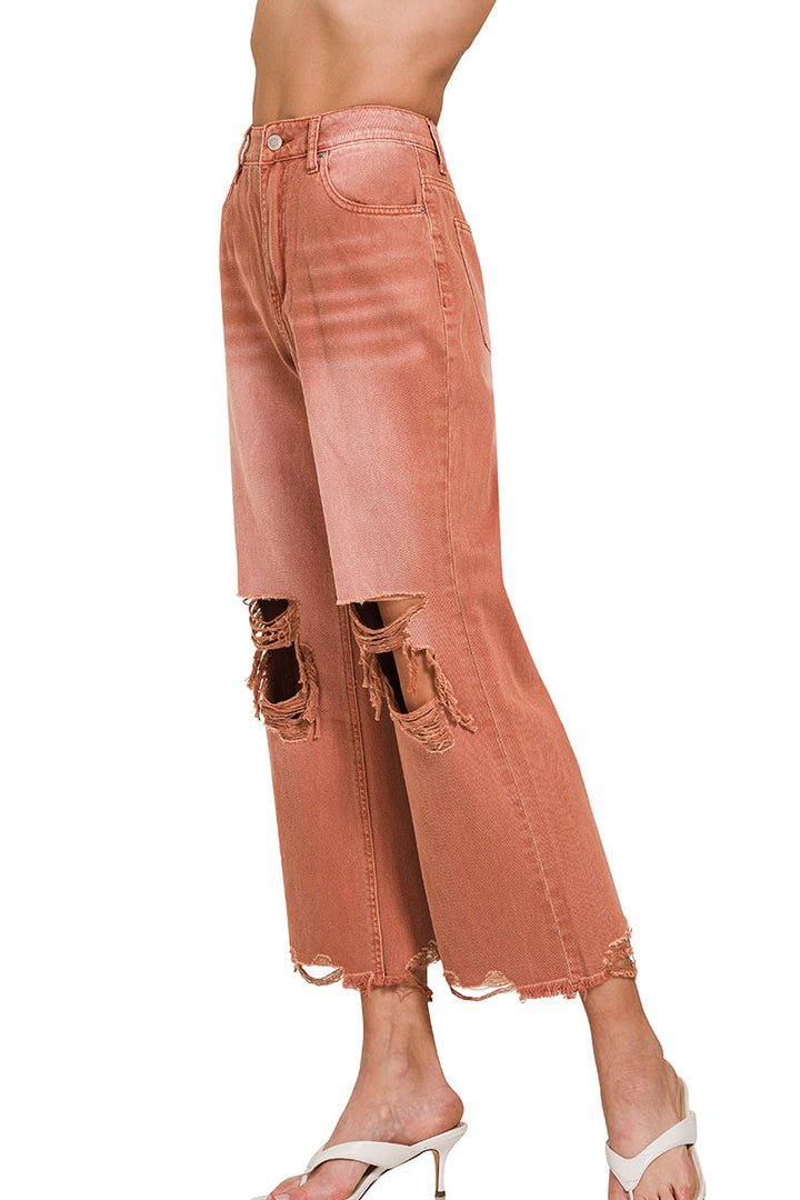 side view of Rust colored distressed knee jeans with raw hemline