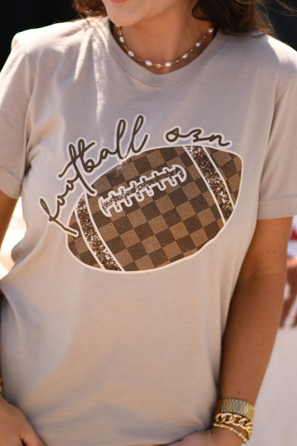 Cream tultex soft tee with brown checkered football graphics.