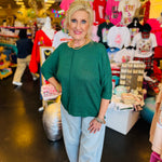 Dark green waffle knit top with boxy fit, raw seam, 3/4 sleeves, and longer back.