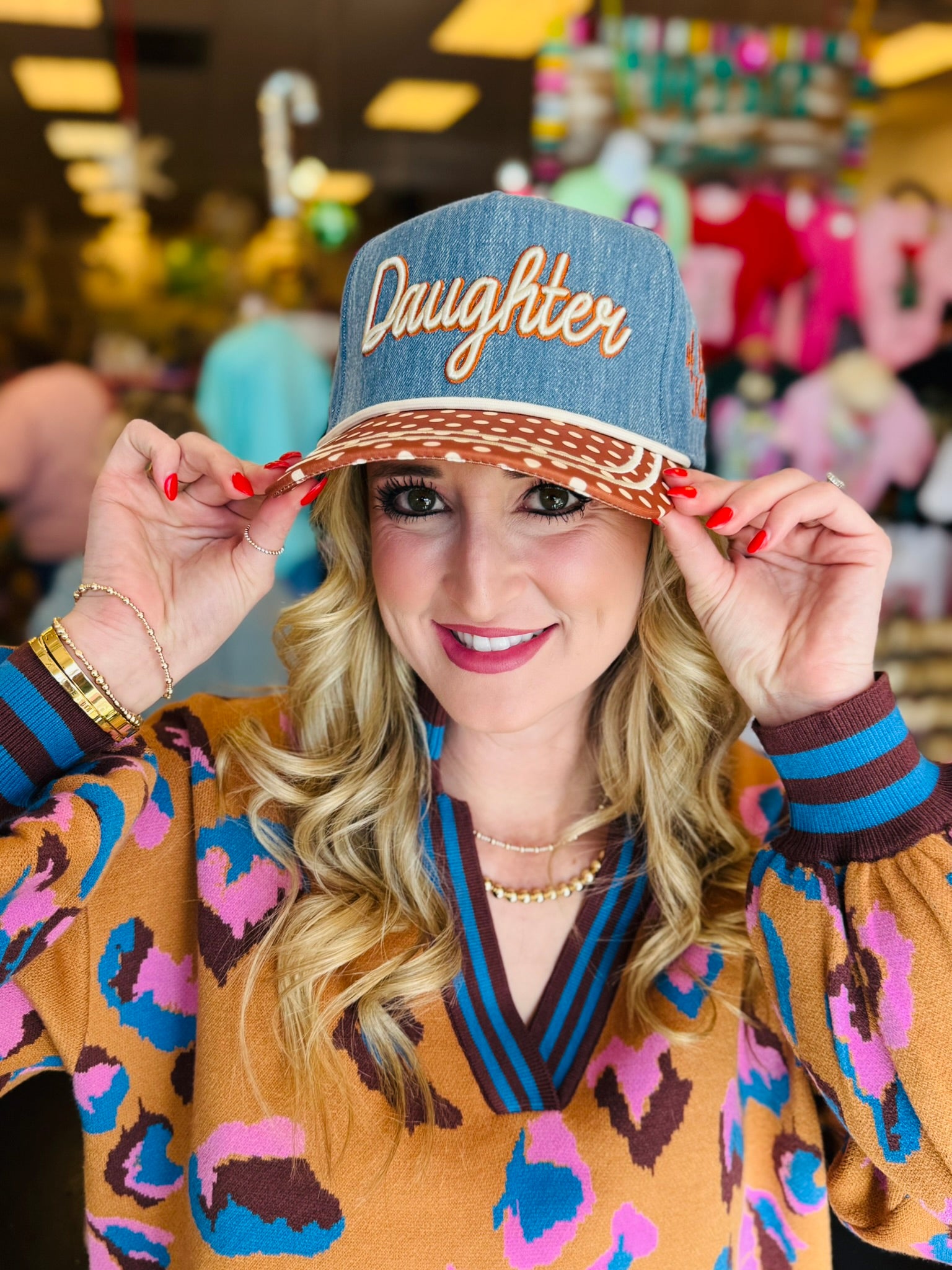 Poppy and Pine Denim-blue “Daughter” hat with brown polka dot bill, cream trim, and “of the King” side embroidery.