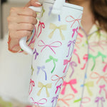 40oz tumbler with spring bow design, flip-straw lid, handle, and car cup holder compatibility.