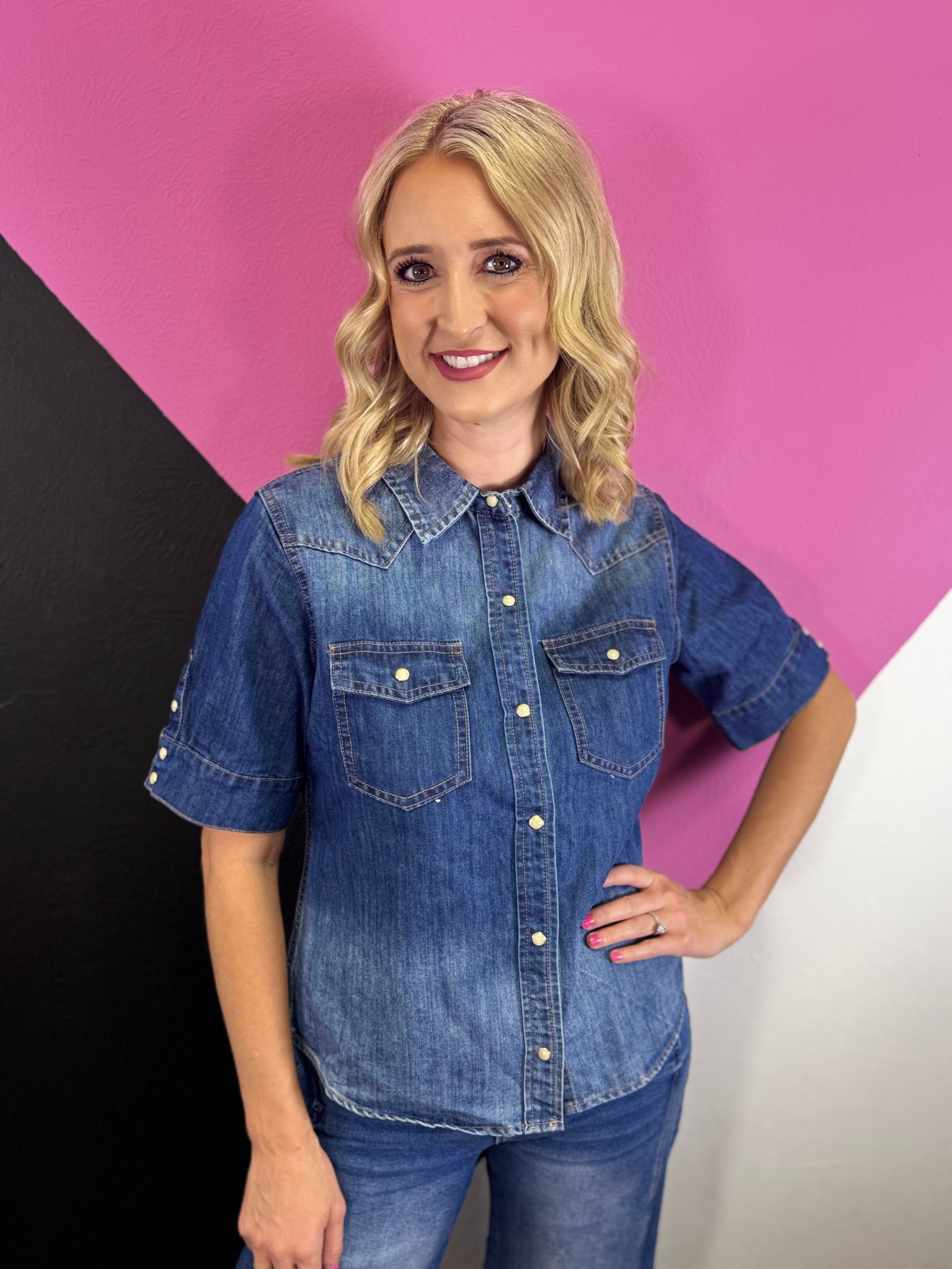 Medium wash denim button up top with snap front, collar, and chest pockets.