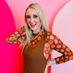 A sheer brown mesh top with a mock neck and colorful pumpkin print.