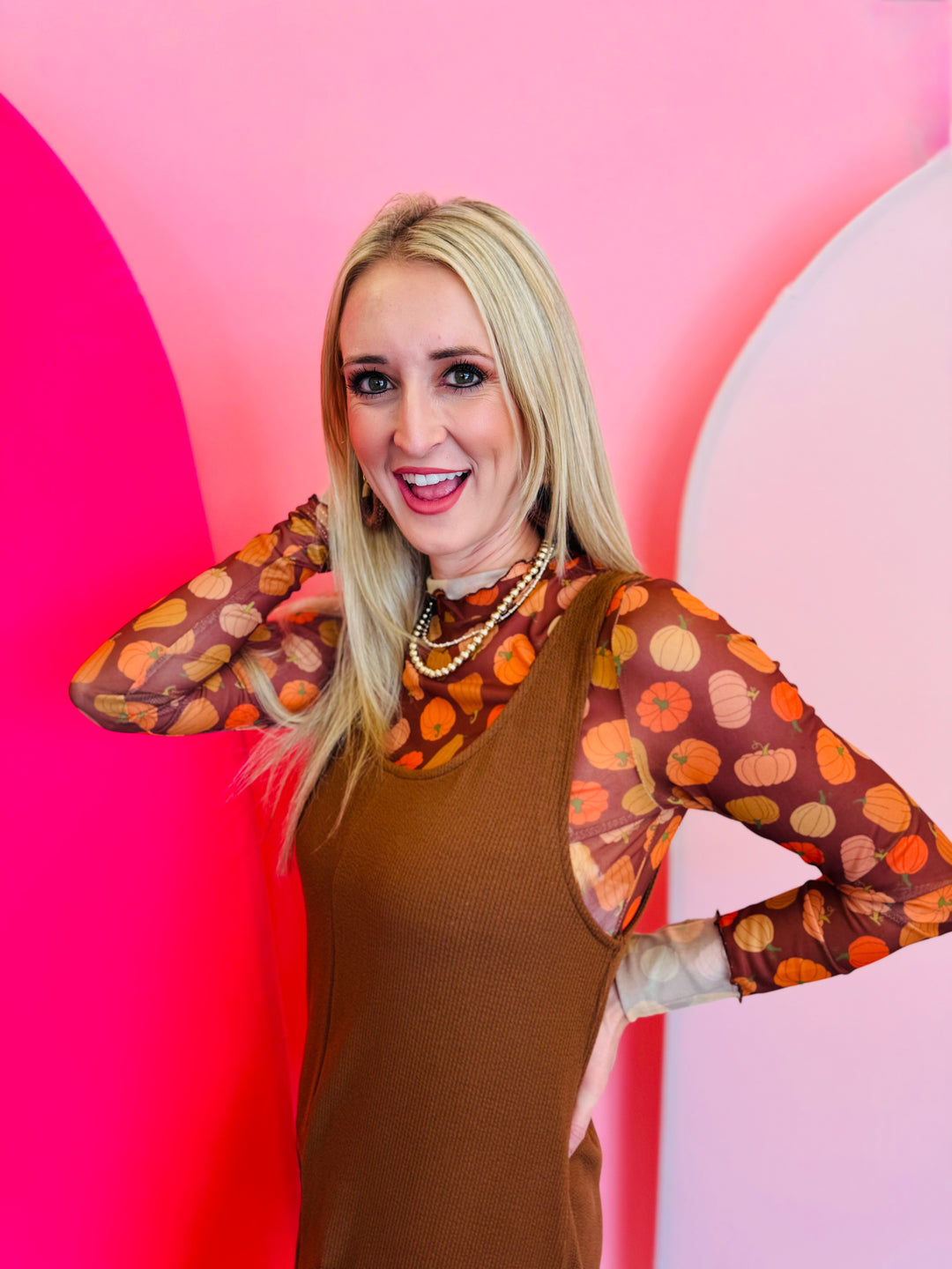 A sheer brown mesh top with a mock neck and colorful pumpkin print.