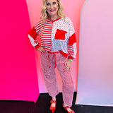 V-neck long sleeve heart print color block pullover top with pocket and ribbed knit details.