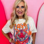 Cream graphic tee with crowned leopard, rhinestone details, and orange and blue artwork.