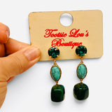 Emerald green and turquoise gemstone drop earrings with glossy beads and gold-tone settings.