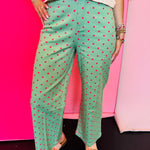 Green wide leg pants with pink polka dots and front button closure.