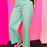 Green wide leg pants with pink polka dots and front button closure.