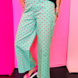 Green wide leg pants with pink polka dots and front button closure.