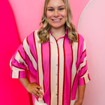 Pink striped button front top with dolman sleeves and collared neckline.