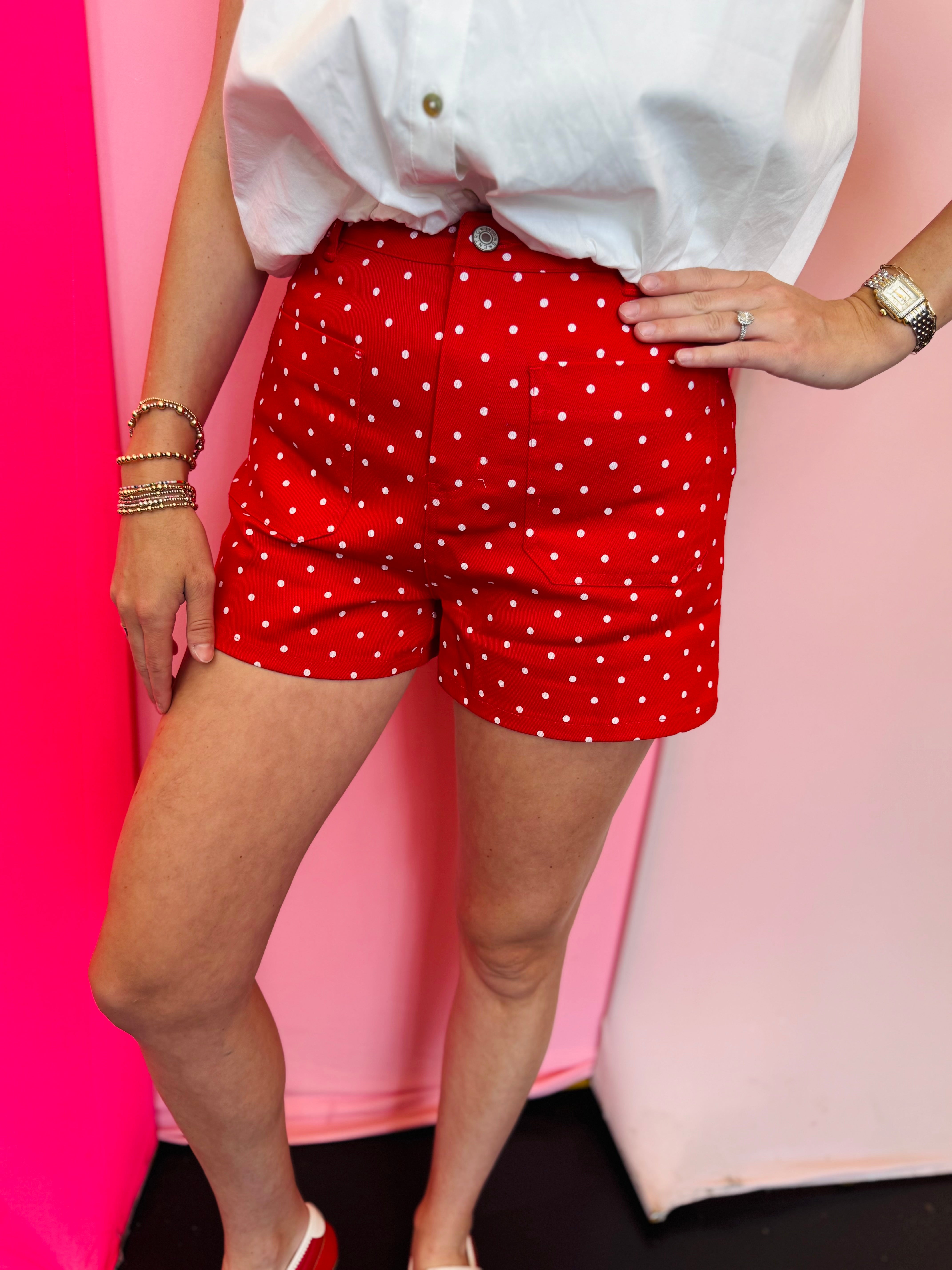 Red polka dot shorts with patch pockets and button front closure.