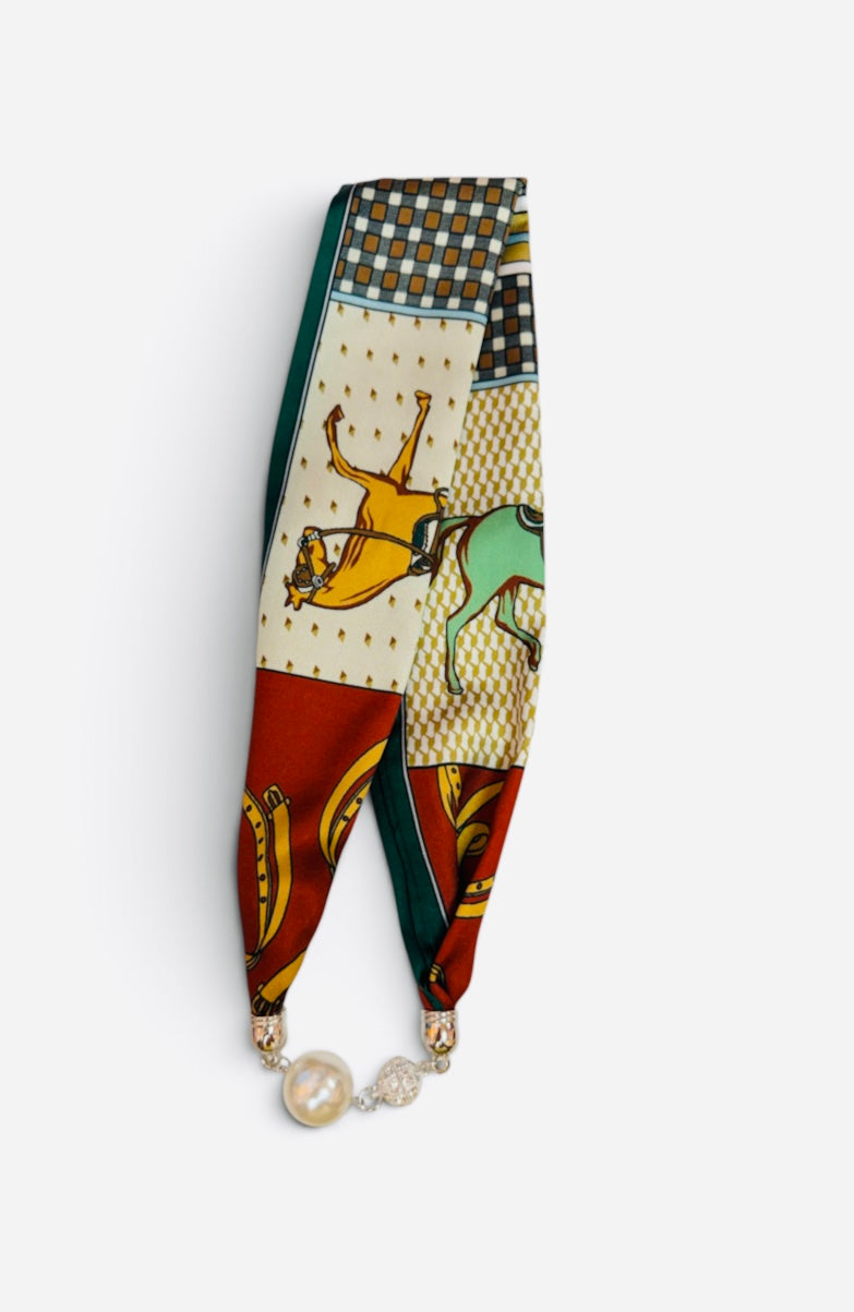 Equestrian scarf necklace with horse prints, pearl accent, and sparkling magnetic closure.
