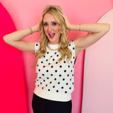 White sleeveless knit top with classic black polka dots in a soft, stretchy fabric blend.