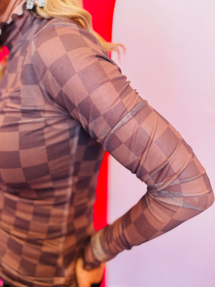 Sleeve view of the Keigan Mesh Top- chocolate checkered print, sheer mesh fabric, and lettuce-edge hems