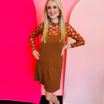 a sleeveless, ribbed-knit jumper dress in a rich chocolate brown color.