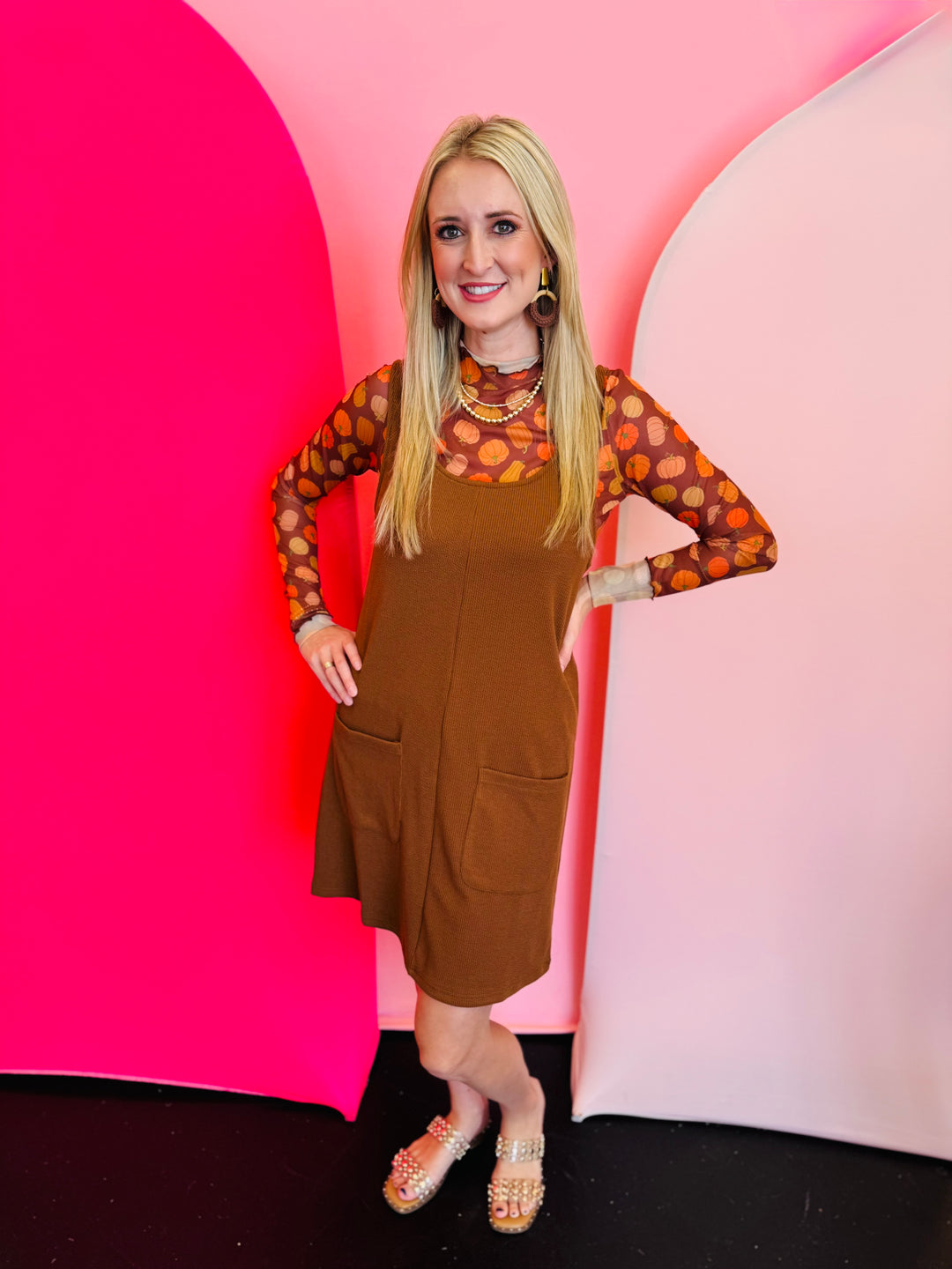 a sleeveless, ribbed-knit jumper dress in a rich chocolate brown color.