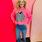 Neon pink crewneck sweatshirt with bold black and white checkered pumpkin graphic, perfect for fall