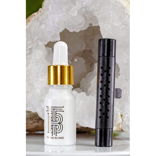Thomas Blonde - A sleek, metallic, cylindrical car vent diffuser clip with a white dot for adjusting fragrance.