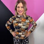 Sheer fall mesh top with orange, black, and cream patterned pumpkins.