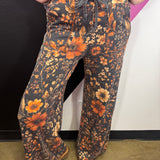Brown floral pants with amber, rust, cream, and earthy vintage-inspired blooms.