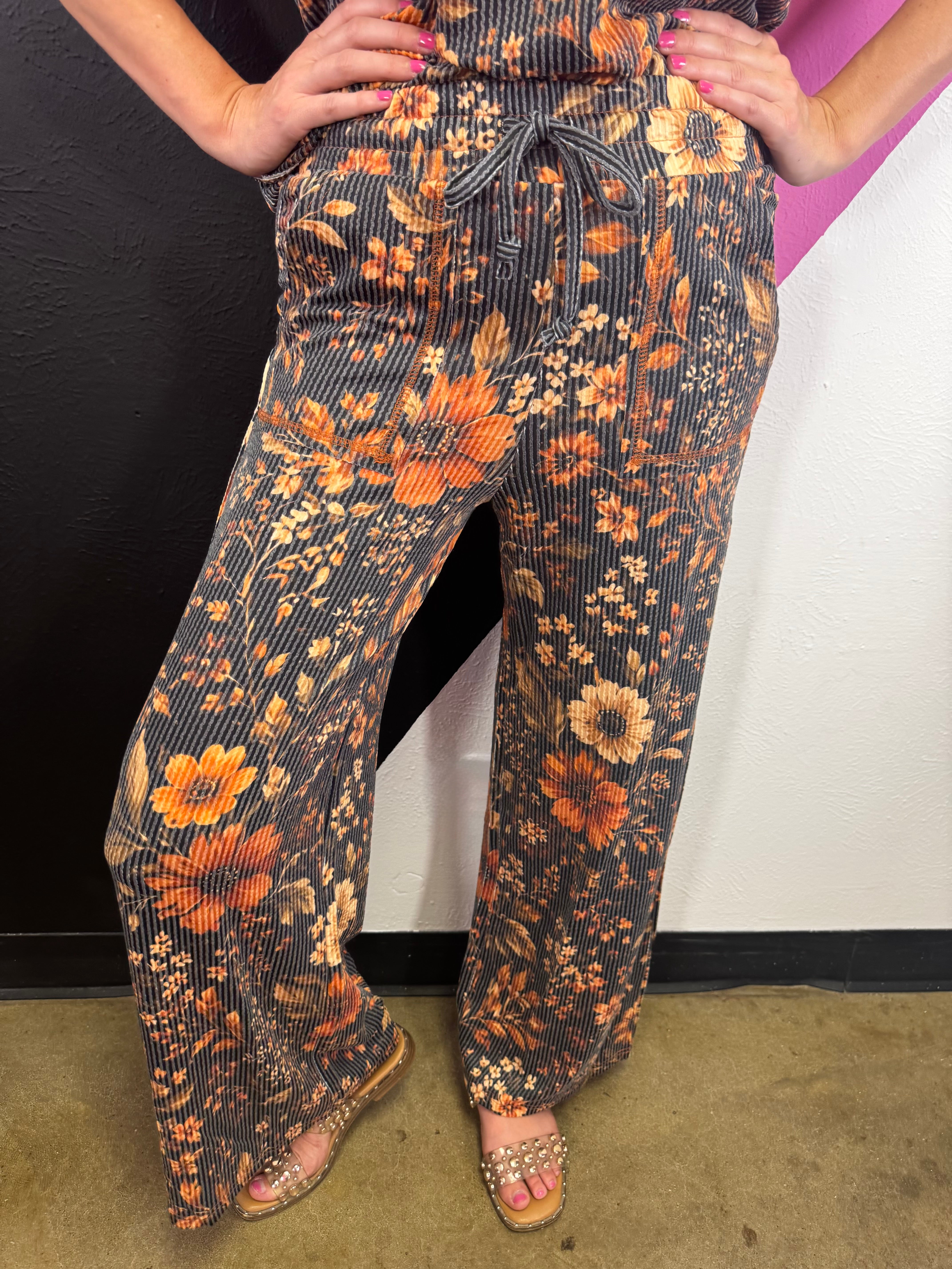 Brown floral pants with amber, rust, cream, and earthy vintage-inspired blooms.