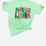 Mint Feeling Lucky graphic tee with pink lettering and shamrock details.