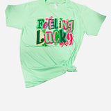 Mint Feeling Lucky graphic tee with pink lettering and shamrock details.