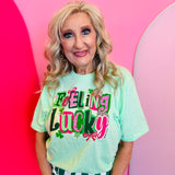 Mint Feeling Lucky graphic tee with pink lettering and shamrock details.